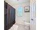 Bright bathroom features a shower, toilet, and elephant decor on the wall at 678 Fiddlesticks Dr, Davenport, FL 33837
