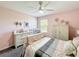 Pink bedroom with ceiling fan, dresser, and window letting in natural light at 678 Fiddlesticks Dr, Davenport, FL 33837
