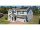 A two-story home showcasing solar panels on the roof and a brick driveway at 678 Fiddlesticks Dr, Davenport, FL 33837