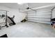 Spacious garage featuring ample room for parking and storage, including work-out equipment and lawn mower at 678 Fiddlesticks Dr, Davenport, FL 33837