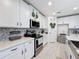 Stylish kitchen with white cabinets, stainless steel appliances, and decorative backsplash at 678 Fiddlesticks Dr, Davenport, FL 33837