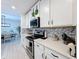 Bright kitchen showcasing white cabinets, stainless steel appliances, and tiled backsplash at 678 Fiddlesticks Dr, Davenport, FL 33837