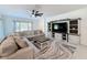 Spacious living room with large sectional sofa, ceiling fan, media center, and natural light at 678 Fiddlesticks Dr, Davenport, FL 33837