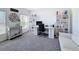 Bright home office with a gray carpet, white desk, shelving, and a comfortable sofa at 678 Fiddlesticks Dr, Davenport, FL 33837