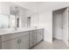 Bright bathroom features a double vanity with grey cabinets, white countertop, and large mirror at 9097 Wildlight Trl, Wildwood, FL 34785
