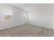 Clean and bright bedroom with neutral carpet and two windows providing natural light at 9097 Wildlight Trl, Wildwood, FL 34785