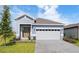 Charming single-story home featuring a paved driveway, manicured lawn, and attached two-car garage at 9097 Wildlight Trl, Wildwood, FL 34785