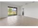 Bright living room with sliding glass doors to the outside and neutral tile flooring at 9097 Wildlight Trl, Wildwood, FL 34785