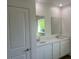 Bright bathroom featuring double sinks, white cabinetry, and a large window overlooking the outdoors at 121 S Cory Dr, Edgewater, FL 32141