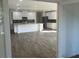 Open-concept kitchen and living area with stainless appliances, white cabinets, and ample counter space at 121 S Cory Dr, Edgewater, FL 32141