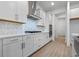 Modern kitchen with white cabinets, gas cooktop and stainless steel range hood at 15086 Summer Harvest St, Winter Garden, FL 34787