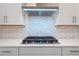 Stainless steel gas cooktop with patterned backsplash and white cabinetry at 15086 Summer Harvest St, Winter Garden, FL 34787