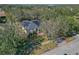 Aerial view of a house with solar panels and a pool, surrounded by lush trees at 3954 Old Dunn Rd, Apopka, FL 32712