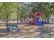 Wooden park bench near a playground in a wooded area at 3954 Old Dunn Rd, Apopka, FL 32712