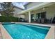 Covered patio with outdoor seating overlooks a private backyard pool and spa with mature landscaping at 471 Lasso Dr, Kissimmee, FL 34747