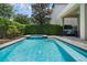 Lush backyard with a sparkling pool, patio, manicured hedges, and privacy fencing at 471 Lasso Dr, Kissimmee, FL 34747