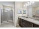 Bathroom with granite countertops, double sinks, glass enclosed shower, and modern fixtures at 471 Lasso Dr, Kissimmee, FL 34747