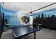 Game room with ping pong and air hockey, featuring eye-catching superhero and city skyline murals at 471 Lasso Dr, Kissimmee, FL 34747