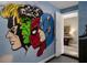 The game room features a lively mural of superheroes, adding a playful and energetic vibe to the space at 471 Lasso Dr, Kissimmee, FL 34747