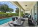 Spacious covered patio with outdoor dining and lounging areas overlooking the sparkling pool and landscaped yard at 471 Lasso Dr, Kissimmee, FL 34747