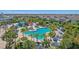 Aerial view of a community pool with slides, palm trees, lounging areas, and lush landscaping at 471 Lasso Dr, Kissimmee, FL 34747