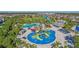 Aerial view of community waterpark featuring pools, slides, splash zone, and mature landscaping at 471 Lasso Dr, Kissimmee, FL 34747