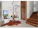 Grand foyer with wood door, cowhide rug, and view into the living room with high ceilings and natural light at 2661 Via Tuscany, Winter Park, FL 32789
