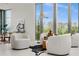 Modern living space with comfortable white chairs and floor to ceiling windows overlooking greenery at 2661 Via Tuscany, Winter Park, FL 32789