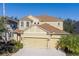 Two-story house with a beige exterior, three-car garage, and landscaping at 1426 Plumgrass Cir, Ocoee, FL 34761