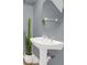 Stylish powder room with pedestal sink, round mirror, and tall cactus plant at 2891 Upper Park Rd, Orlando, FL 32814