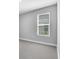 Bedroom with a large window with blinds and grey carpet floors at 2982 Arranmore Dr, Ormond Beach, FL 32174