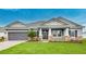 Charming single-story home with a two-car garage and a covered front porch, set against a blue sky at 2982 Arranmore Dr, Ormond Beach, FL 32174
