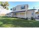 Charming two-story home with a welcoming porch, surrounded by lush greenery and palm trees in a serene setting at 1043 Lemon Bluff Rd, Osteen, FL 32764