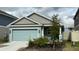 Single-story home with light teal garage door and landscaping at 207 Aqua Ave, Davenport, FL 33837