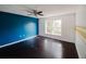 Bedroom with blue accent wall, dark floors, and natural light at 2824 Corrigan Dr, Deltona, FL 32738