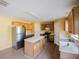 Kitchen featuring an island, tile flooring, stainless steel refrigerator and wood cabinetry at 2824 Corrigan Dr, Deltona, FL 32738
