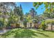 Inviting backyard with lush green grass, a small patio area, privacy fence, and mature trees at 786 Antonette Ave, Winter Park, FL 32789