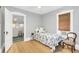 Bright bedroom with a patterned bedspread, wood floors, and natural light from a large window at 786 Antonette Ave, Winter Park, FL 32789