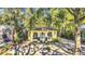 Charming yellow house with arched windows, nestled among mature trees and lush landscaping at 786 Antonette Ave, Winter Park, FL 32789