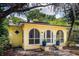 Charming yellow home featuring arched windows and a cozy front entrance, surrounded by lush greenery at 786 Antonette Ave, Winter Park, FL 32789