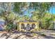 Charming yellow bungalow with arched windows, blue planters, and lush mature landscaping at 786 Antonette Ave, Winter Park, FL 32789
