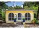 Charming yellow home featuring arched windows and a welcoming front entrance with potted plants at 786 Antonette Ave, Winter Park, FL 32789