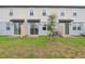 Townhome exterior with private back patio and freshly planted small tree in the yard at 16332 Happy Eagle Dr, Clermont, FL 34714