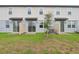 A well-maintained backyard features a grassy area, a small tree, and patio spaces with sliding glass doors at 16332 Happy Eagle Dr, Clermont, FL 34714