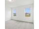 Bright bedroom featuring two large windows and plush carpeting at 16332 Happy Eagle Dr, Clermont, FL 34714