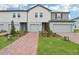 Modern townhomes feature a brick walkway, manicured landscaping, and attached garages, offering curb appeal at 16332 Happy Eagle Dr, Clermont, FL 34714