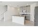 Open kitchen with granite island, gray cabinets, stainless steel appliances and white walls at 16332 Happy Eagle Dr, Clermont, FL 34714