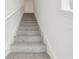 Carpeted staircase with white banisters, providing a comfortable transition between levels of the home at 16332 Happy Eagle Dr, Clermont, FL 34714