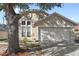 Tan house with attached garage and mature landscaping at 230 Bay Meadow Dr, Kissimmee, FL 34746