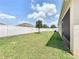 Spacious backyard with lush lawn, white fence, and partial view of the screened-in patio, ideal for recreation at 236 Barrington Dr, Haines City, FL 33844